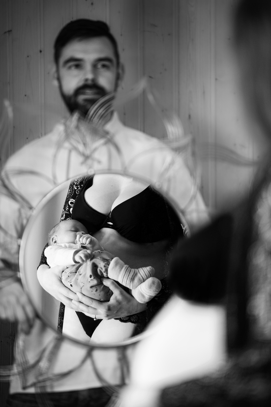 Babybauchshooting vorher/nachher: Schwangere steht vor dem Spiegel, den der werdende Papa h�lt: Im Spiegel hat sie das Kind im Arm